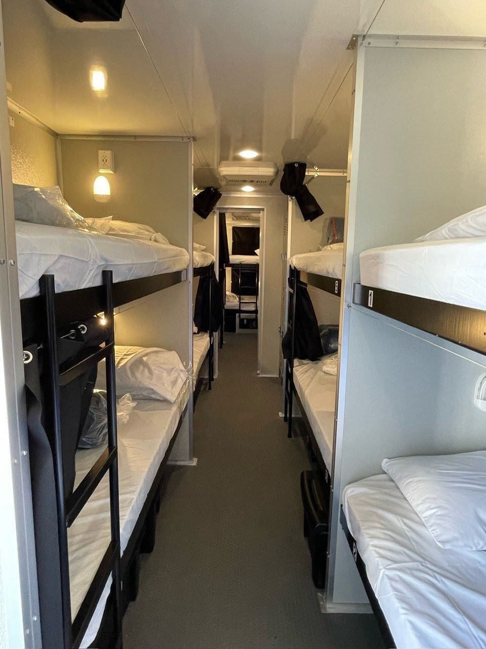 Interior of a bunk housing trailer with made beds.