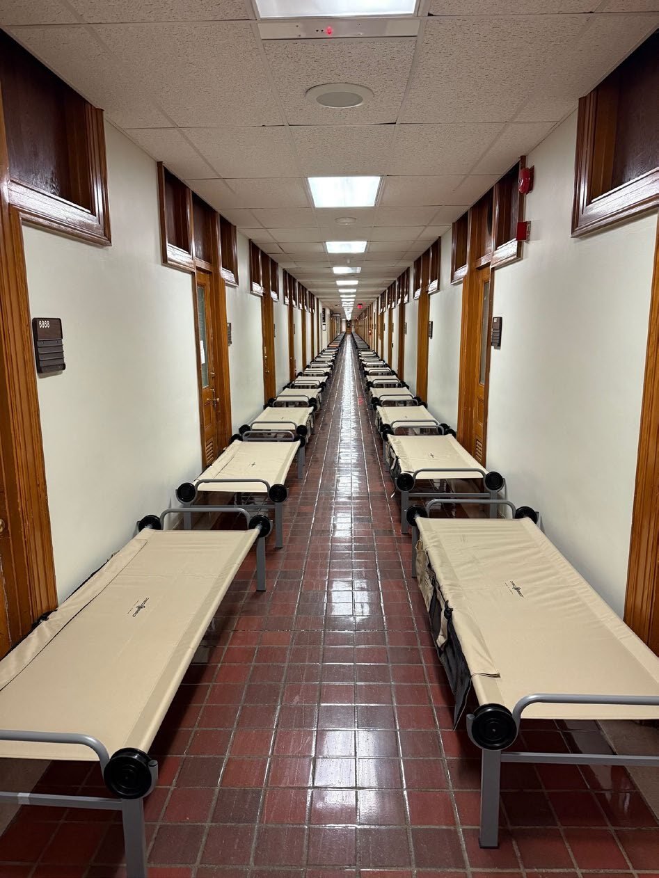 Rows of cots arranged for a National Guard deployment.