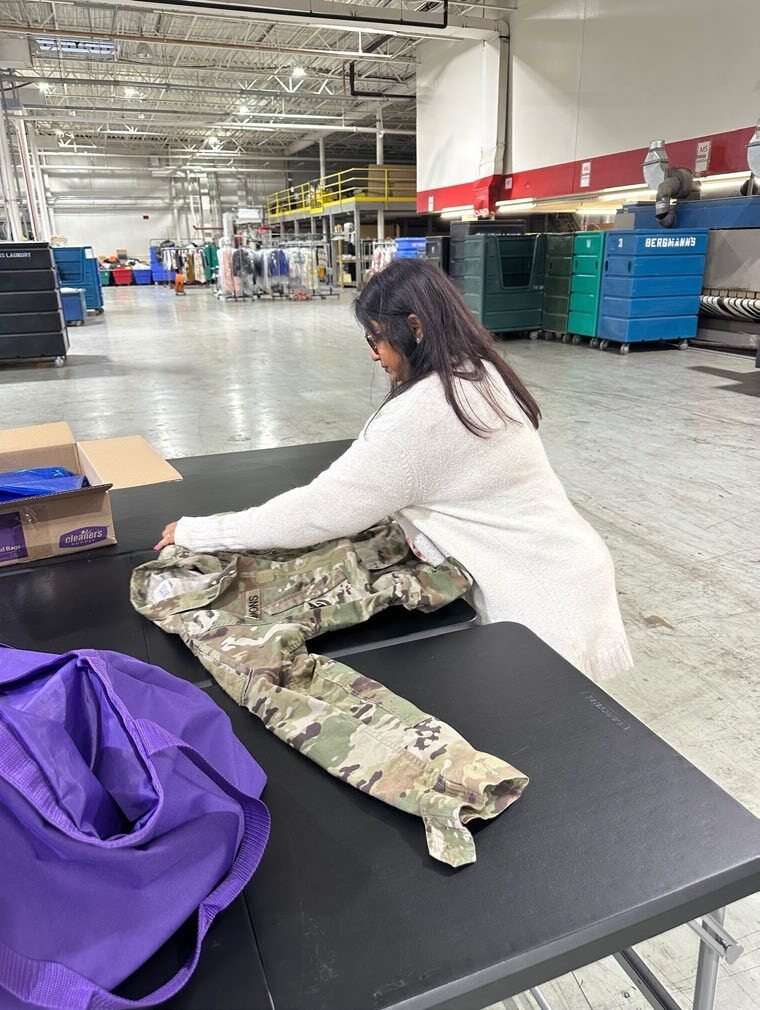 Staff member folding laundry at a commercial laundry operation.