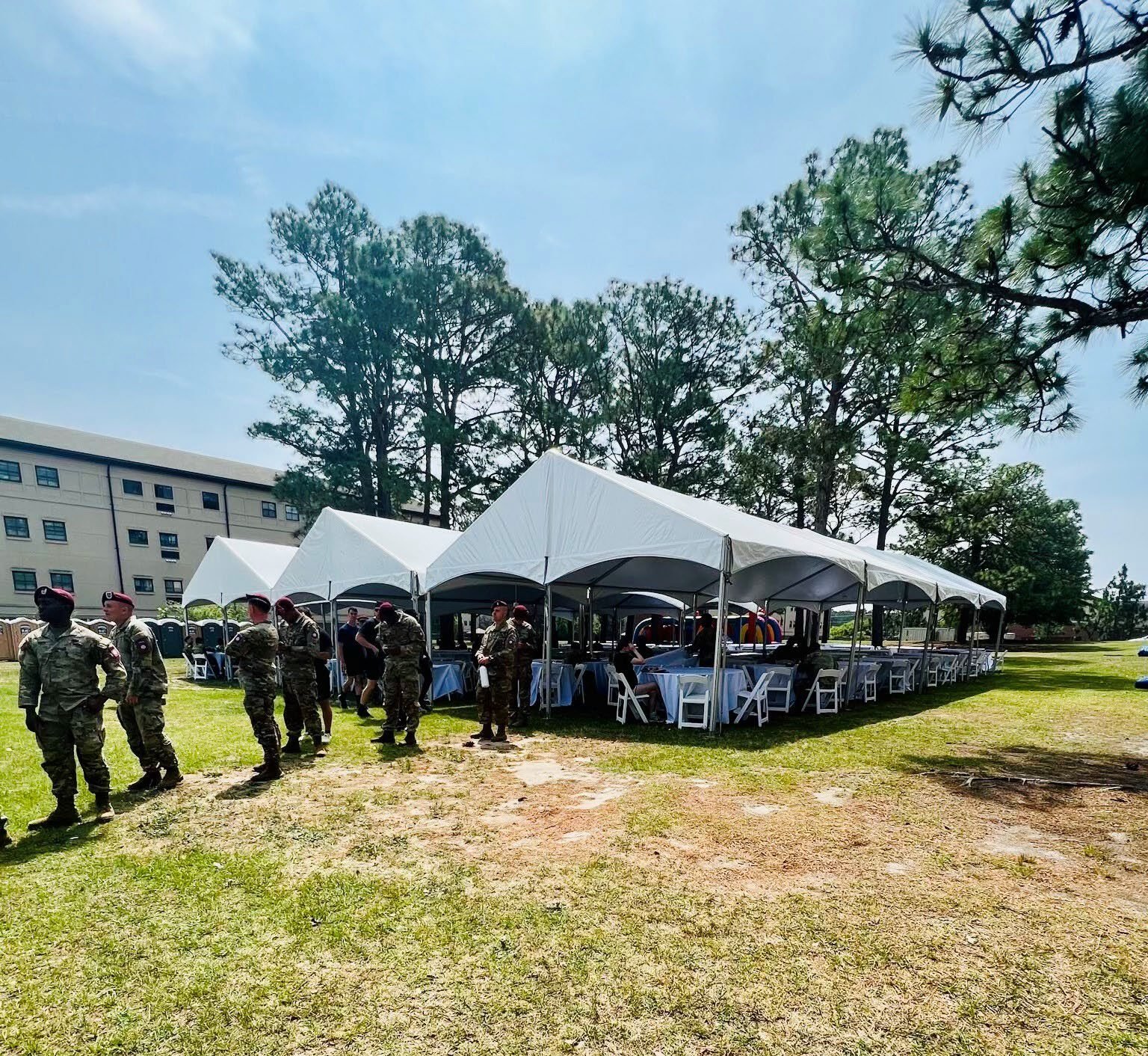 Tents and troops formed up at a military base camp event.